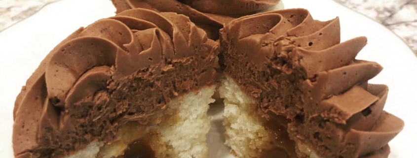 Twix Tribute Cupcake: Vanilla cupcake with caramel filling, chocolate buttercream and Twix candy