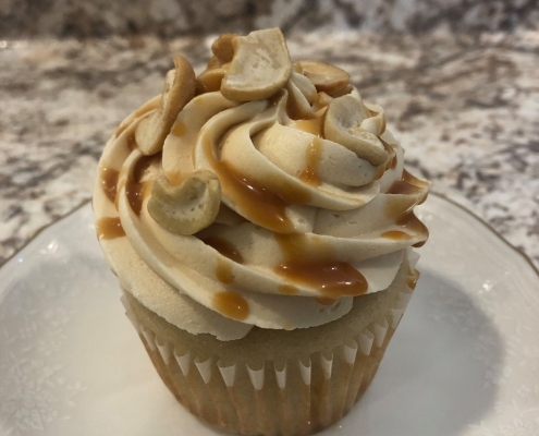 Caramel Cashew Bar Cupcake: Vanilla cupcake with salted caramel buttercream, caramel sauce drizzle and chopped cashews