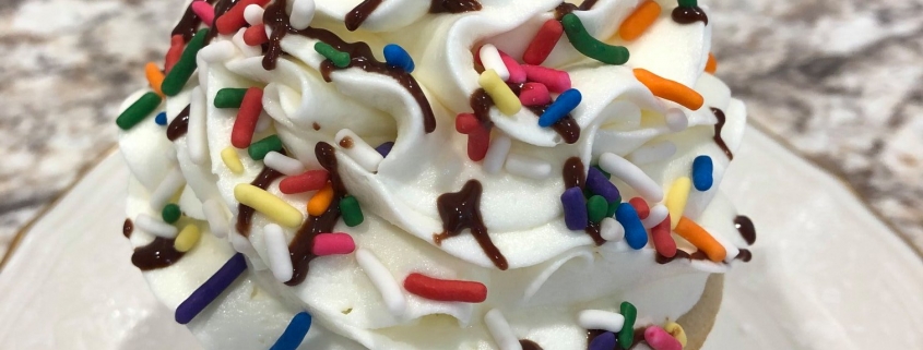 Celebration Cupcake: Vanilla cupcake with vanilla buttercream, chocolate ganache drizzle, rainbow sprinkles and a maraschino cherry