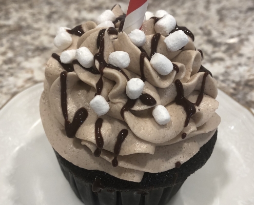 Cozy Cocoa Cupcake: Chocolate cupcake with hot cocoa buttercream, chocolate ganache drizzle and marshmallow bits