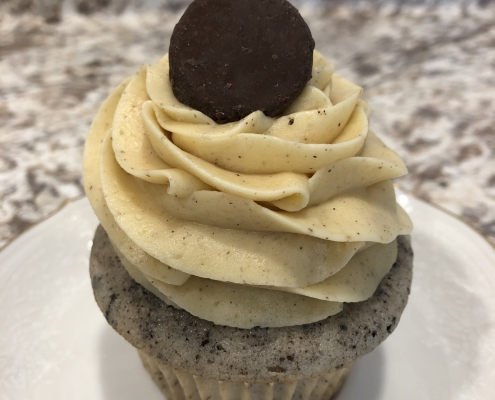 Pumpkin Oreo Cheesecake Cupcake: Cookies-n-creme cupcake with pumpkin cream cheese buttercream and a mini chocolate covered Oreo