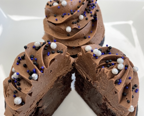 Midnight Magic Cupcake: Chocolate cupcake with chocolate ganache filling, dark chocolate buttercream and sprinkles